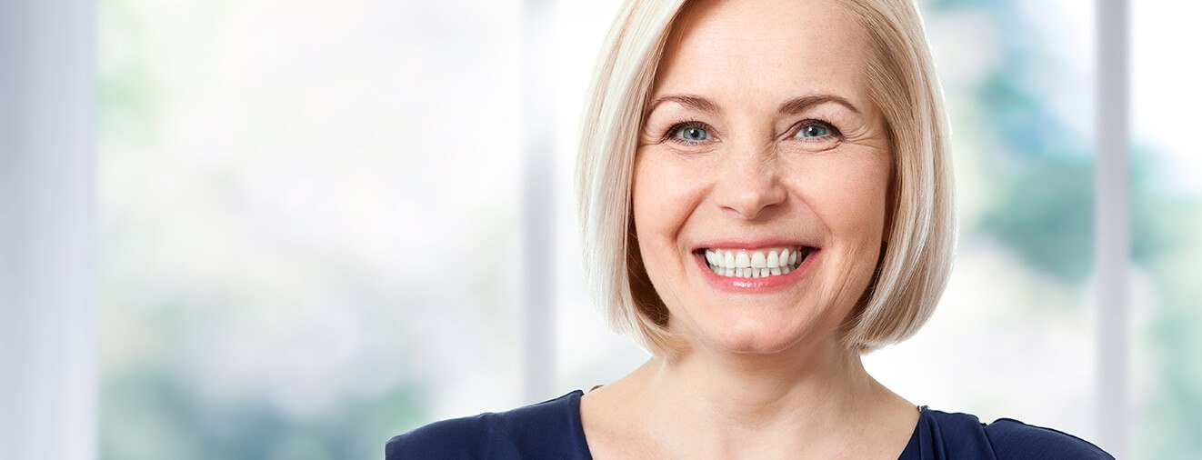 Older woman smiling after fat transfer procedure