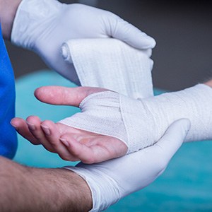 Doctor wrapping patient’s hand after surgery