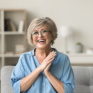 Happy senior woman holding her hands close to her heart