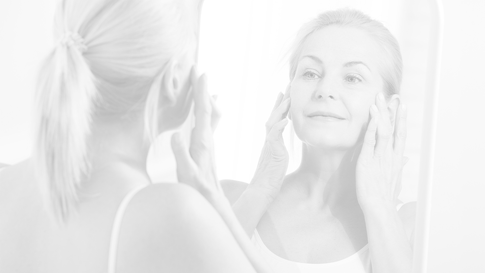 Woman looking in mirror after the Renuvion J-Plasma procedure