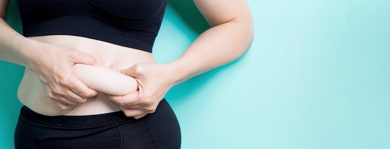 Person in need of tummy tuck pinching belly fat