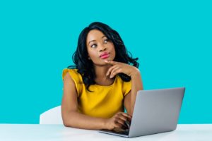 Young woman sitting at computer, curious about BOTOX®